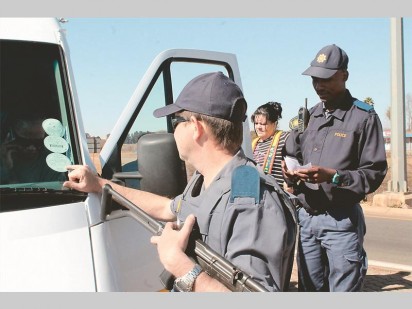 The Tarlton Police Station held a roadblock to check for roadworthy vehicles, illegal items and valid driver's licences before the long weekend commences. Warrant officer Dennis Jones checks to see if this taxi's licence is up to date. With him is constable Steven Segakweng and principal typist Martie Mans.