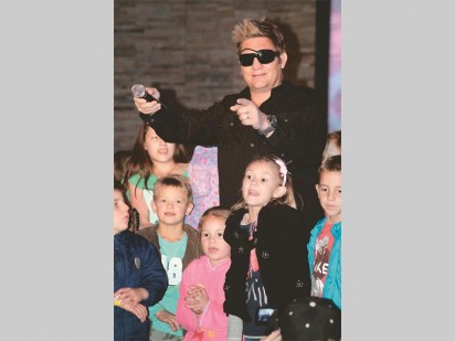 Kurt omring deur kinders tydens sy optrede. 
