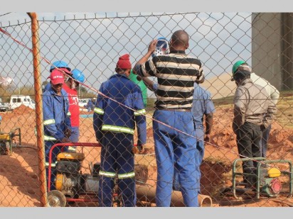 Werkers besig om te werk aan die watertoevoer probleem.