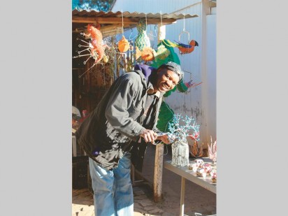 Joseph Ketche of Hotwired finishing off a wire-and-bead baobab tree.