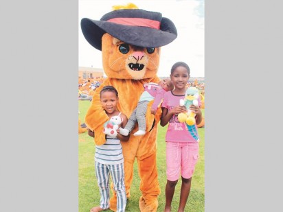 The Krugersdorp Family Violence, Child Protection and Sexual Offences Unit (FCS)  handed out teddy bears to children at a march to raise awareness about child and women abuse. From the left is Tisetso Tumelo (7), Bobby Cat (the FCS's mascot) holding Musa Serapelo (6 months) and Refilwe Piua (10).