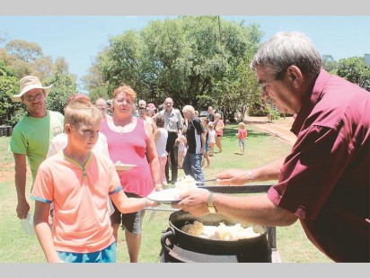 Leon Ehrke (links), 'n barmhartige gemeenskapsvrywillger besig om pap vir die inwoners van Villa Gloria in te skep.