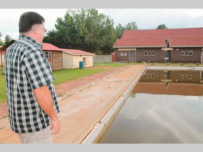 Johann Calitz, skoolhoof van Hoërskool Monument by die skool se swembad wat na die vloed van 31 Januarie skade opgedoen het. Hulle vermoed dat water iewers uit die swembad lek.