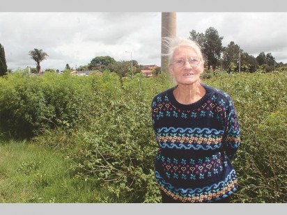 Rita Herbst (74) van Krugersdorp-Noord by die lang gras en bossies by die Bodensteinstraat Park wat glo sowat 'n jaar laas behoorlik in stand gehou is.