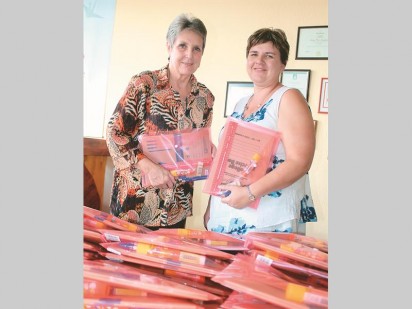 Minnie Pretorius, Rotary Anns president (links) oorhandig 51 stelle basiese skryfbehoeftes aan Annemart Koekemoer van Krugersdorp Town School.