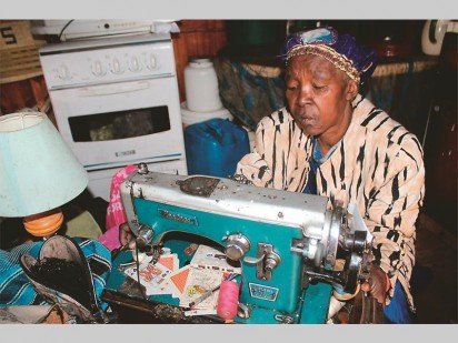 Clara Ntsepo (62) in her one room shack where she sews clothes and makes beads to help her community.