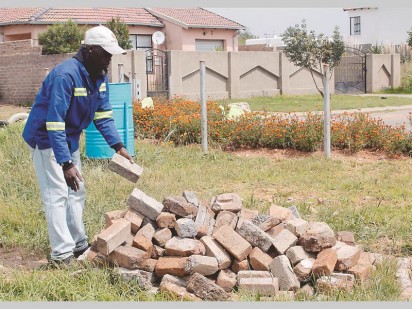 Tlhatlhogo Oatlhotse with some of the bricks to be used for a braaistand they are planning.