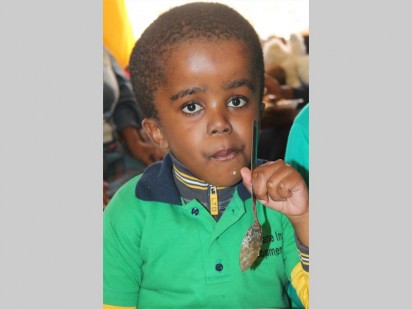 Thato Moloto enjoying a meal police officers prepared for the children of Rekopane Inclusive Centre.