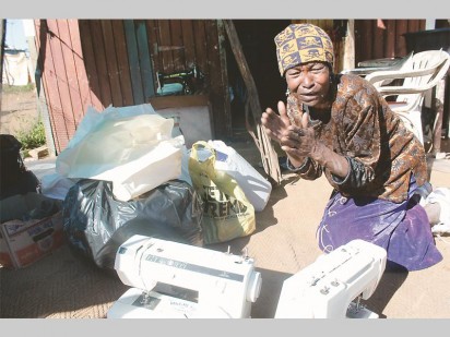 Clara Ntsepo, a resident of the Soul City informal settlement showing how grateful she is for the sewing machines she received.