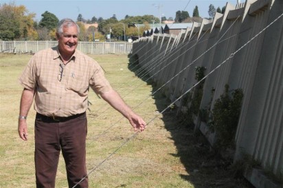 DA councillor Jakkie Naudé standing next to the dilapidated Burgershoop Cemetery fencing.