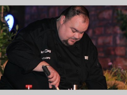 Vaatjie van Toks 'n Tjops besig om die vleis op die kole te braai.