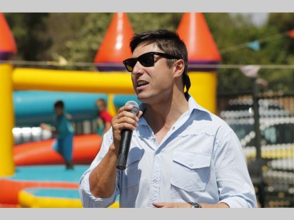 Gerrie Pretorius sing van sy bekende treffers terwyl die kinders in die agtergrond op die springkasteel baljaar.