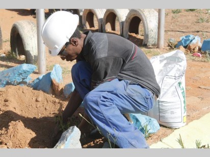 Lesego Ramagole, one of the Boltonia Park volunteers hard at work planting flowers sponsored by President Hyper.