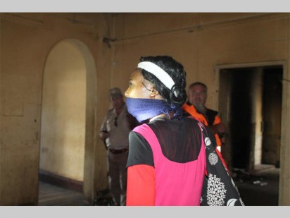 A suspected woman of the night entering the house and walking to her room while ignoring officials who were raiding it.
