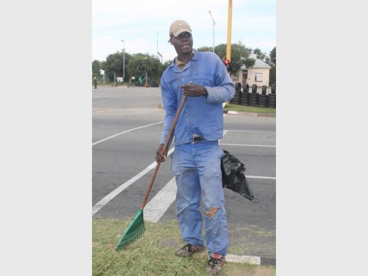 Brian Ngwenya busy raking in leaves, grass and other rubbish along Albertina Sisulu Road in Mindalore.