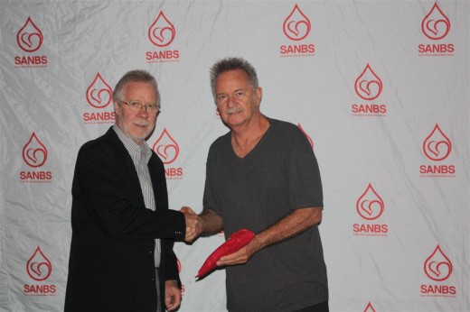 Rob Theunissen (left), Chairman of Board of Directors for the South African Blood Services (SANBS) congratulates Robert Meerts for donating 250 units of blood. The third highest milestone of the event.