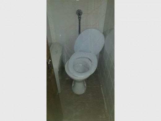 Die sitplek van die toilet is nie eers aan die bak vas nie.
