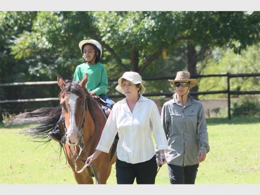 Liam de Waal enjoys his therapeuthic sessions on Sunny's back while instructor Natalie Stobäus and volunteer Jill Minnie keeps a watchful eye.
