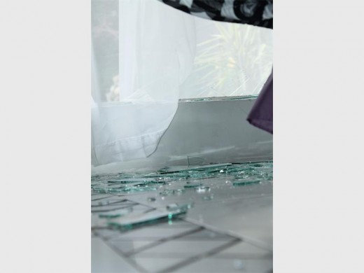 Scattered glass everywhere as robbers entered through a broken window.