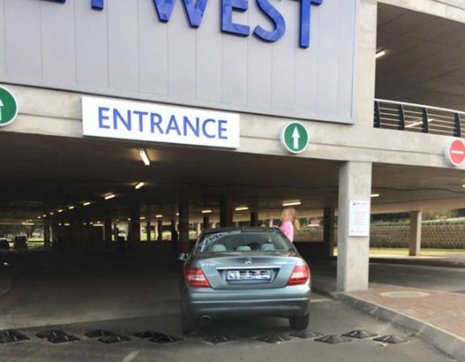 A child is seen hanging from a vehicle en route to the underground parking of Key West Shopping Centre.