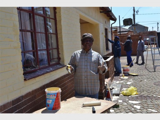 David Makoko and fellow congregants in the background painting the church house. Photo: Sipho None.