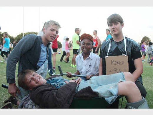 Ethan Vetton gets pushed around in a wheelbarrow after he broke his leg weeks before the race. In the back is Kian Smith, Kgothatso Chapi and Kelvin Robinson.