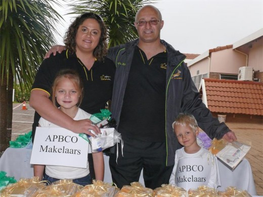 Yvette Hattingh en Derek Crots van Abco Makelaars het verskeie geskenkpakkies wat hulle uitdeel. Voor van links is hulle kinders Leaney Hatting en Dale-Erik Crots.
