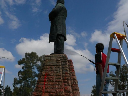 JJ Kritzinger spuit verf van die Paul Kruger standbeeld af.