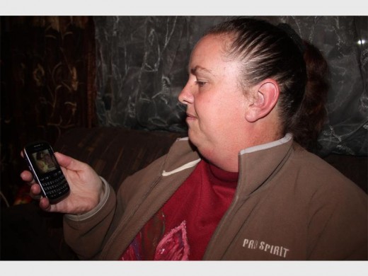 Monica Jansen van Rensburg met 'n foto van haar seun op haar selfoon voordat hy verlede jaar Junie wreedaardig in Burgershoop vermoor is.