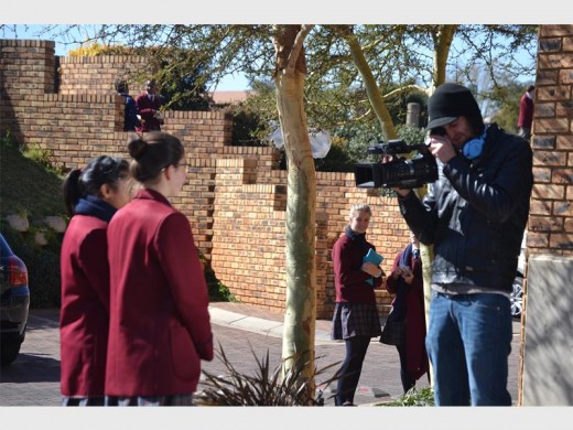 Nuuskierige leerlinge staan en staar soos die manne van Green Productions mede-leerlinge afneem.