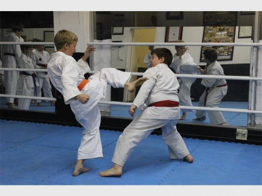 Orange-belt karateka Kyle Cronje delivers a quick kick towards Eugene de Wet at the TKC dojo.