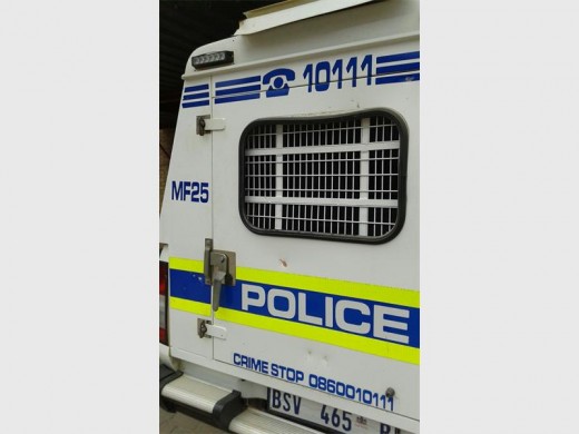 Members of an informal settlement dent police van with stones.