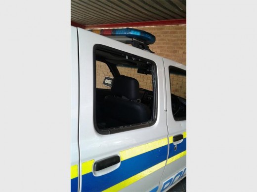 Windows to a police vehicle thrown out by angry community members.