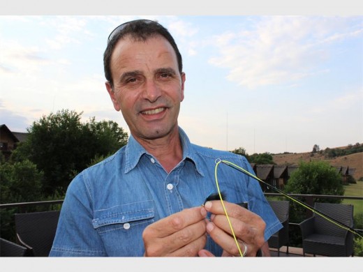 Gilbert attaching a fly to his fly-fishing rod.