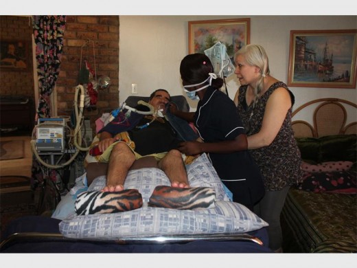 Deon being assisted by one of his two nurses who helps Bernice during the day.