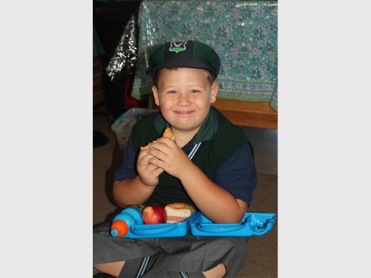 Janzen Stolz geniet sy gesonde kospakkie wat sy ouers vir hom saam gestuur het op sy eerste dag van groot skool.