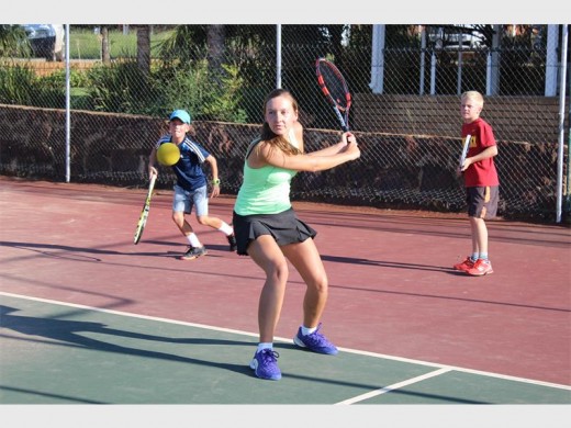 Michaela Maritz swings at the ball during a doubles match.