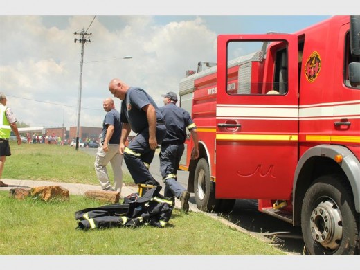 A Mogale City Emergency Services member suit up as they get ready to fight the flames.