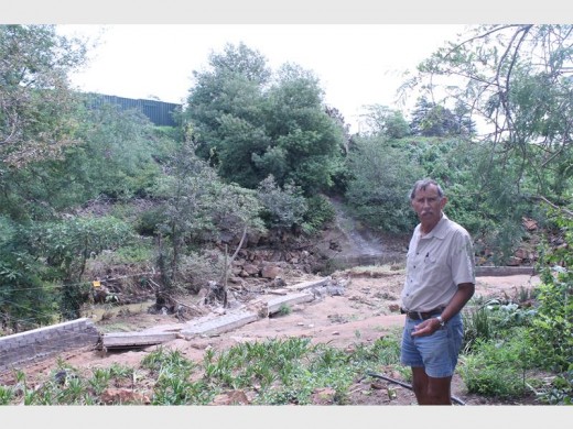 Frikkie Gebhardt, eienaar van die plot, wys die News hoe die onlangse reën sy nuut geboude mure verwoes het toe die spruit oorstroom het aan die begin van Februarie.