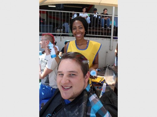 Mbali Mahlangu spraying Francois Dreyer's hair.
