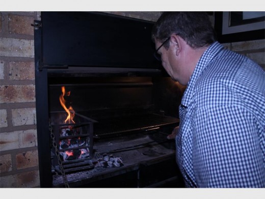 Theo van der Walt maak seker die vuur is reg om te braai.