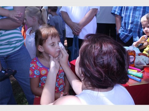The children stood in rows to get their faces painted.