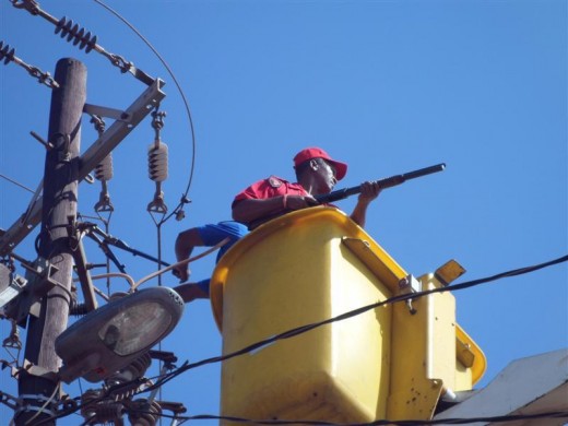A Red Ant official guarding a Mogale City official who is busy disconnecting illegal connections in Munsieville in February. Photo: Supplied