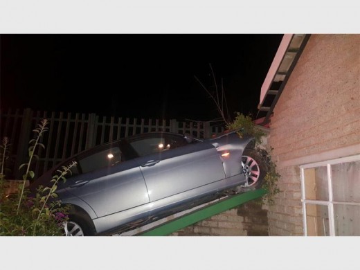 The BMW missed the living room window by a metre after crashing through the wall.