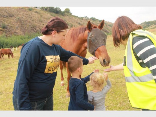 CPF patroller Sonja Gilliat, along with Ilona Coetzer, Zayden Coetzer and Amber Jones reaching out to greet a friendly horse in the kloof.