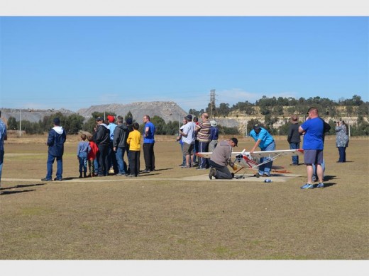 Enthusiasts watching the aerobatics, while others worked on their models.
