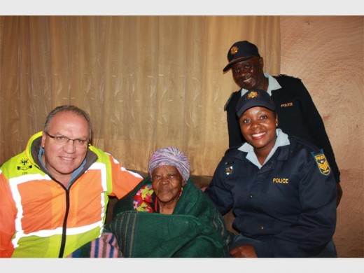 Krugersdorp CPF Exco chairperson Gert Jonker, Krugersdorp Police Station Commander Brigadier Baloyi and Sergeant Tshepiso Mashale handed a blanket to an elderly resident of Munsieville.