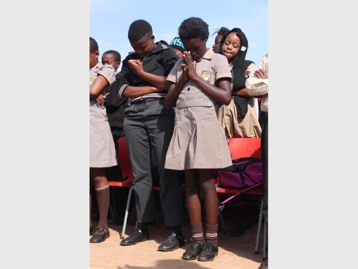 Pupils from Munsieville Primary bow their heads for a moment of silence on International Child Protection Day.