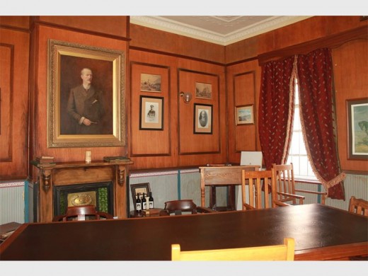 The original dining room at the Gentleman's Club, where paintings of former chairpersons decorate the wood-paneled walls.
