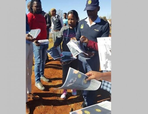 Constable Lucky Matome handing out domestic violence pamphlets to community members. Photo submitted.